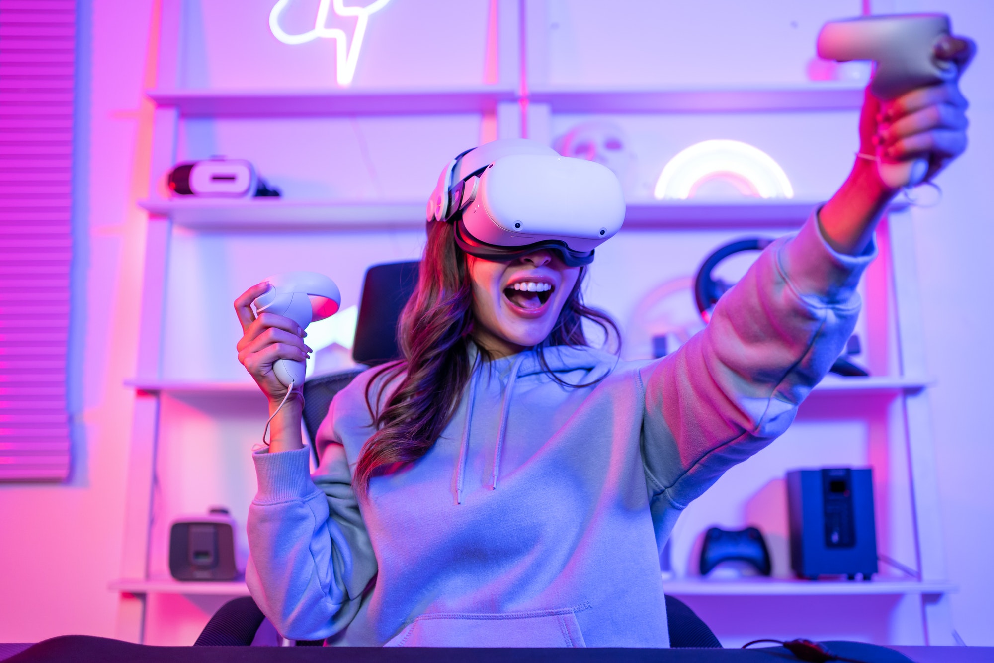 Asian young esport woman gamer use technology VR glasses and play game.