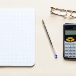 squared paper , pen, eyeglasses and calculator