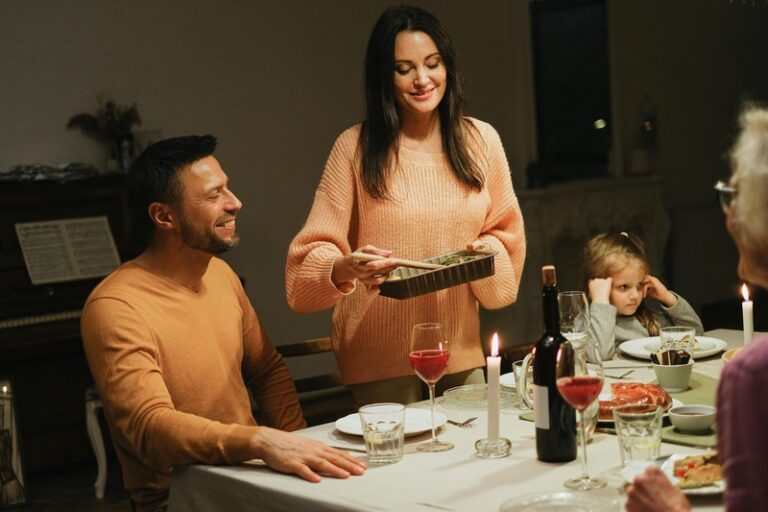 Family style dinner at an agriturismo in Tuscany with pasta and wine on a wooden table
