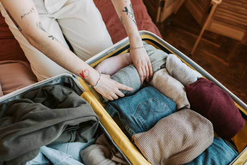 Travel packing essentials laid out for a farm stay in Italy including walking shoes