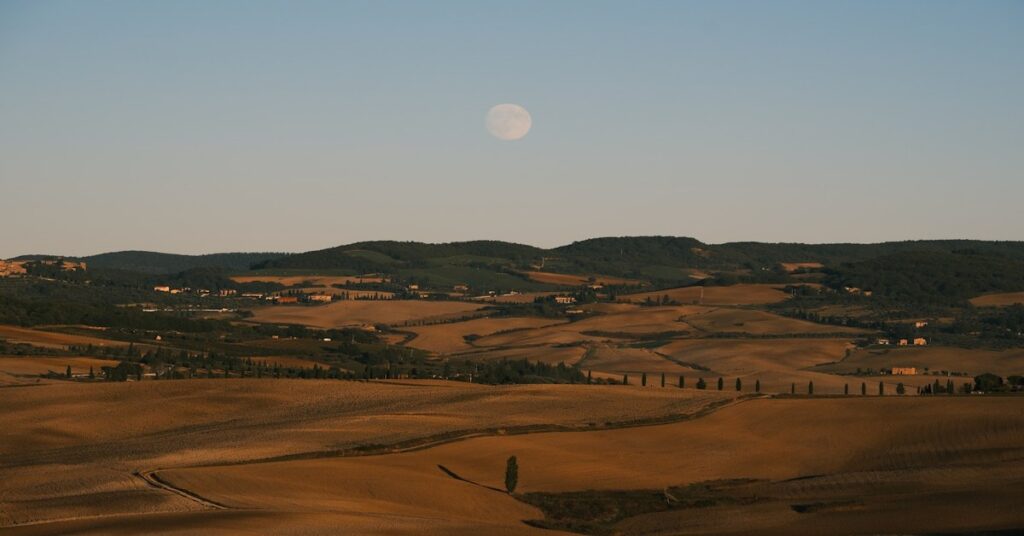Milky Way visible over rolling Tuscan hills at night with a dark sky full of stars