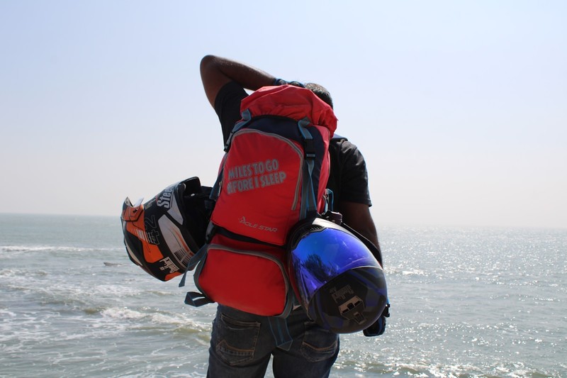 A rider wearing a wide brim hat, long sleeved shirt, boots, and carrying a small backpack for a vineyard ride