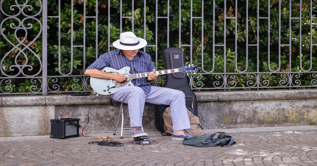 Guests gathered around a table at an Italian farm-stay singing with a guitar player in a rustic dining room