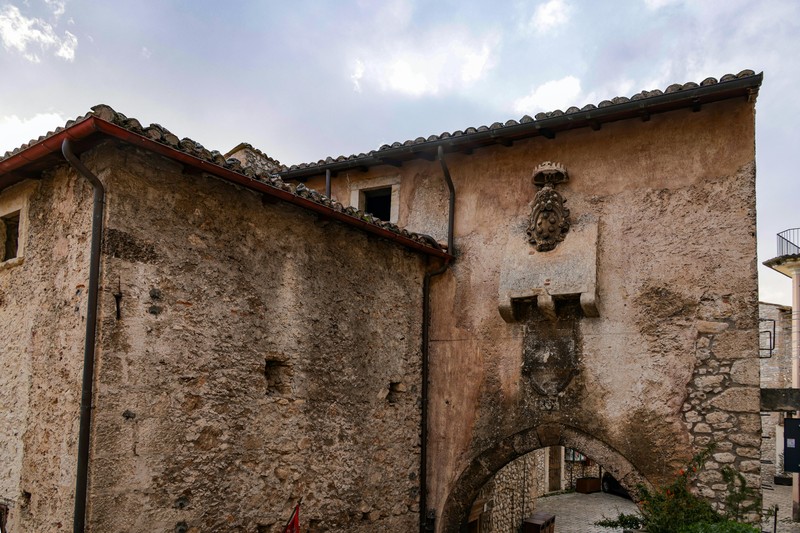 Workers harvesting olives and pressing them at a traditional stone mill in Italy
