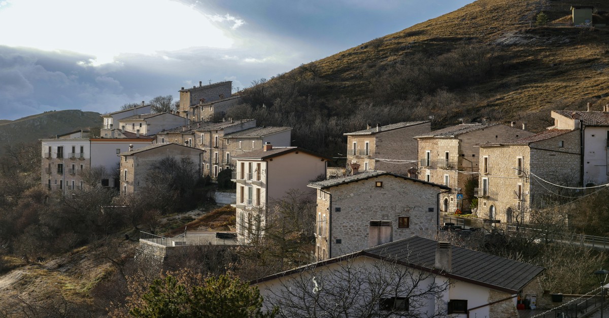 Italian village sagra with communal tables under a tent in a historic piazza