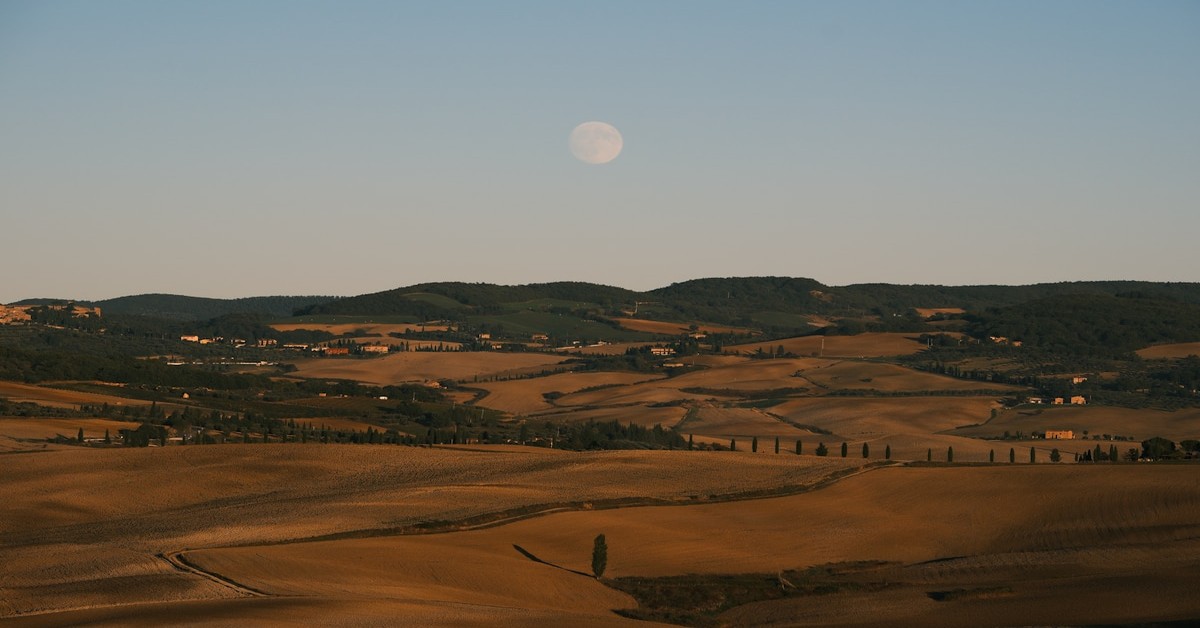 Milky Way visible over rolling Tuscan hills at night with a dark sky full of stars